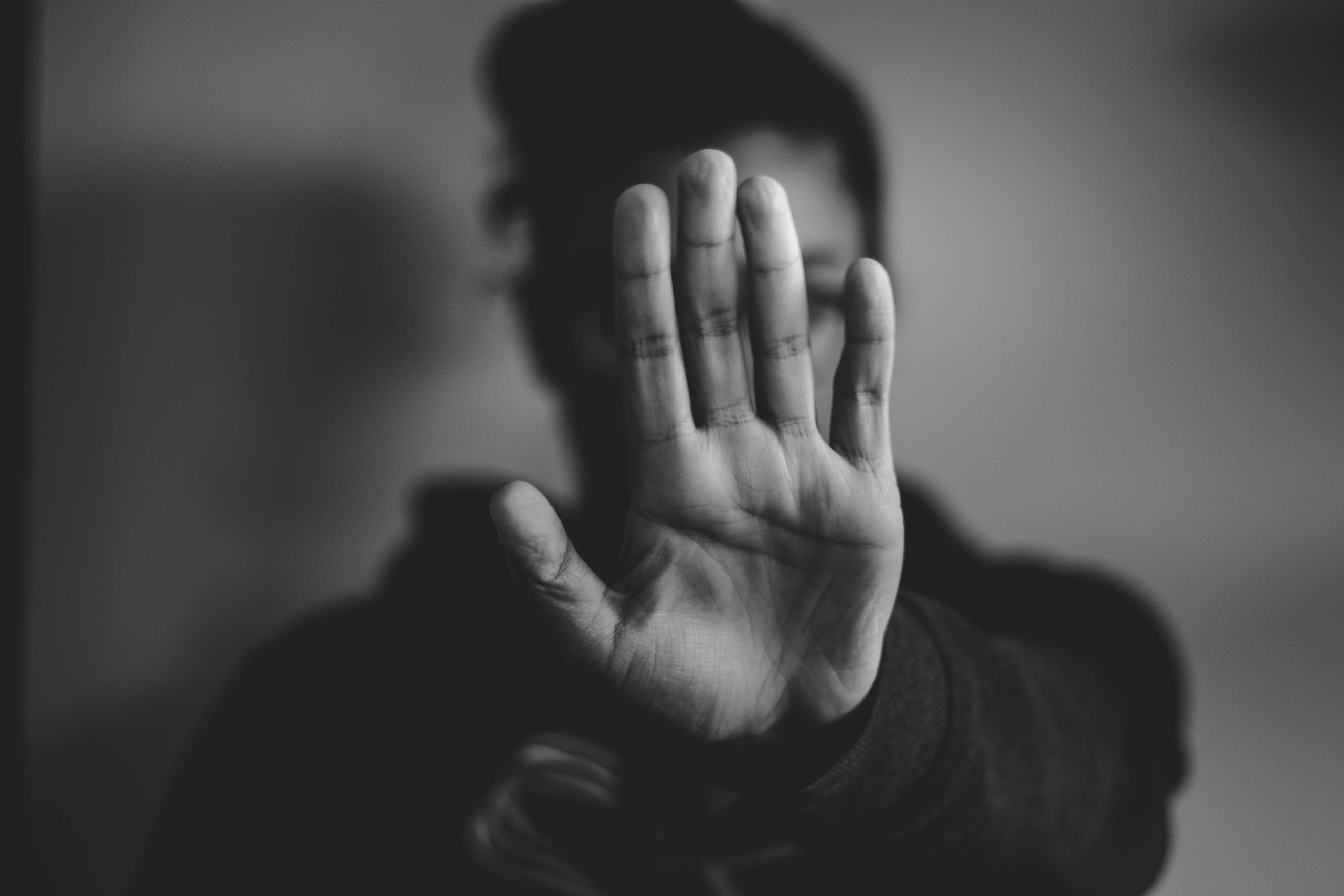 Boy with his hand held up in a stop position.